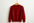 red cashmere sweater on a coat hanger with white background